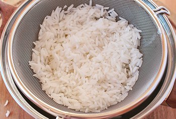 Промытый и отваренный рис откинутый на дуршлаг