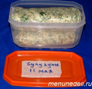 Колбаски из сулугуни из зелени завернутые в пищевую пленку и помещенные в контейнер для заморозки