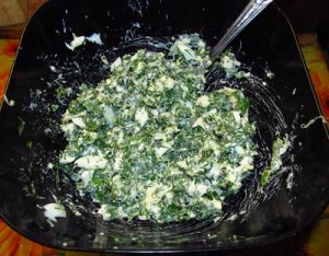 Отваренные и мелко порубленные яйца смешиваются с зеленью натертым сыром и майонезом