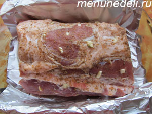 Кусок мяса  натертое специями и нашпигованное чесноком в фольге