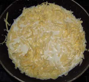 Добавляем в молоко тертый сыр и нагреваем до растворения сыра