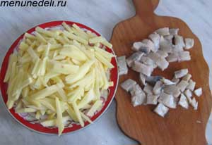 Нарезанные кусочками картофель и селедка для супа