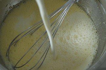 Во взбитые яйца с сахаром и солью наливается молоко
