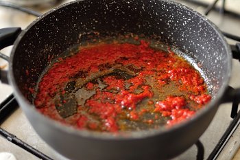 В разогретом растительном масле растворяется томатная паста для приготовления рисовой каши