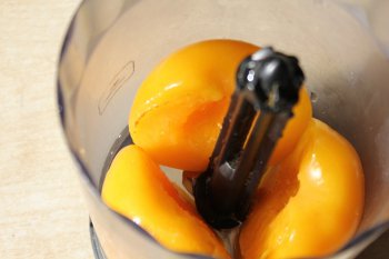 Половинки консервированного персика помещены в блендер