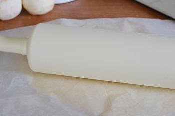 Тесто из холодильника раскатывается между слоями пергамента