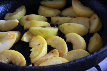 Яблоки обжариваются на сковороде с сахаром