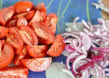 Порезанные лук полукольцами и помидор дольками для салата с шампиньонами