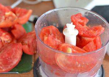 Вымытые помидоры с вырезанной плодоножкой порезаны на части