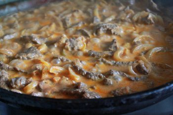 К мясу добавляем лук томатную пасту и остальные ингредиенты Бефстроганов из говядины тушится до готовности