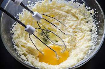 Добавляется яйцо в масляно-сахарную смесь для печенья