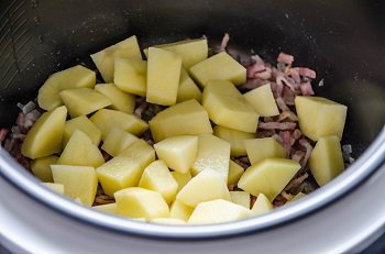 К луку и бекону добавляется порезанный крупными кусками картофель
