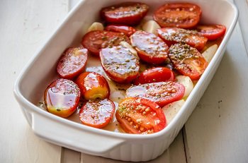 Выкладываем помидоры и чеснок в форму для запекания 