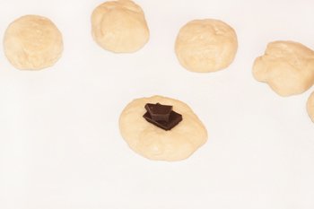 Кусочки шоколада выкладываем на кусочки дрожжевого теста