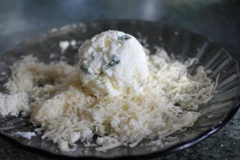 Шарик из сырной смеси обваливается в сухарно сырной смеси