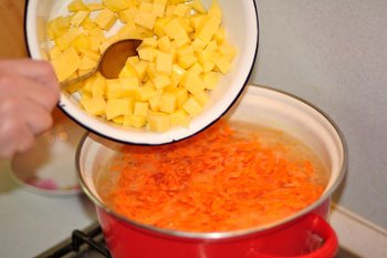В бульон добавляем картофель кубиками и мелко порезанную морковь