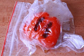 Запеченный болгарский перец остывает в полиэтиленовом пакете