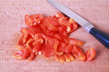 Очищенный болгарский перец нарезается тонкими кусочками