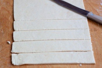 Раскатанное тесто режется на одинаковые полоски