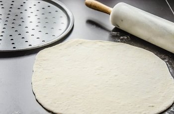 Подготовленное тесто для пиццы раскатываем на два круга