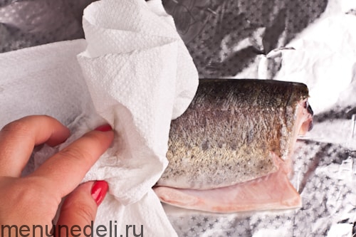 Подготовленная рыба на фольге - радужная форель, фаршированная лимоном и петрушкой