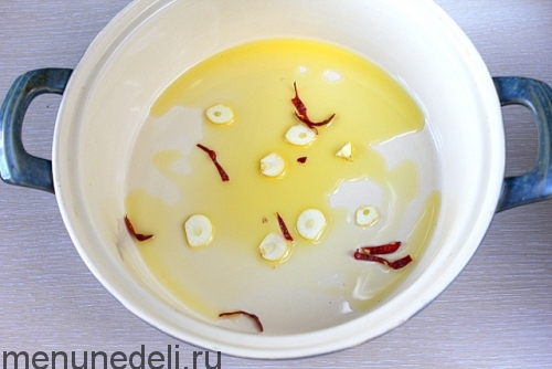 Оливковое масло на сковороде с чесноком и чили - филе трески с помидорами и каперсами