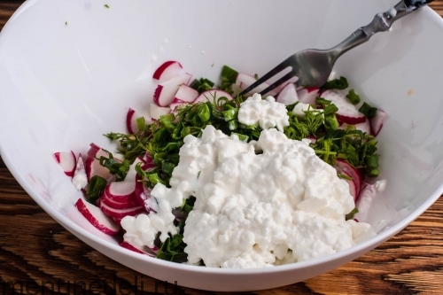 Редис, зелень и зернистый творог в миске - салат из редиса с творогом